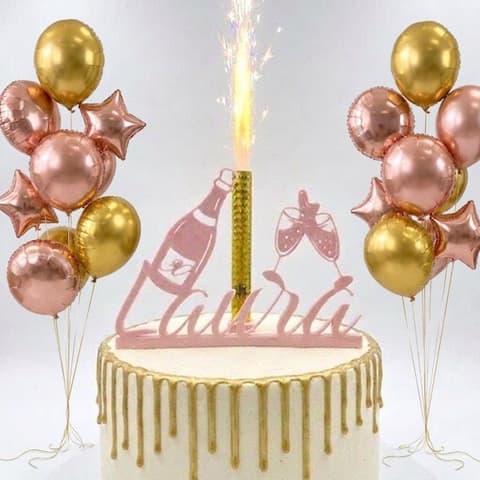 Personalised name cake topper in rose gold with a lit ice fountain on a white celebration cake